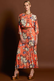 A model wearing the Jolene Pleated Maxi Dress in colour Tangerine, from the front, showing the whole outfit