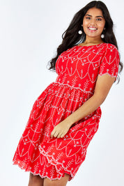 Model Shanaya wearing size 14 of the Printed Fit And Flare Dress in colour Embanglais (Red), from the front, cropped image