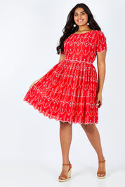 Model Shanaya wearing size 14 of the Printed Fit And Flare Dress in colour Embanglais (Red), from the front, showing the whole outfit