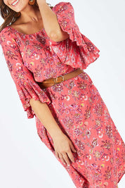 Model Abby wearing size 14 of the Off Shoulder Floral Dress in colour Persimmon (Pink), from the front, cropped image