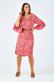 Model Abby wearing size 14 of the Off Shoulder Floral Dress in colour Persimmon (Pink), from the front, showing the whole outfit