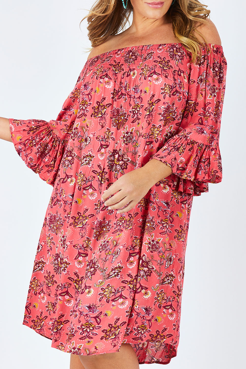 Model Fiona wearing size 16 of the Off Shoulder Floral Dress in colour Persimmon (Pink), from the front, cropped image