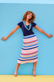 Model Summer wearing size 10 of the Pleated Stripe Skirt in colour Pleated (Pink), from the front, showing the whole outfit