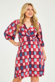 Model Katie wearing size 16 of the Gathered Waist Faux Wrap Dress in colour Checkered (Red), from the front, cropped image