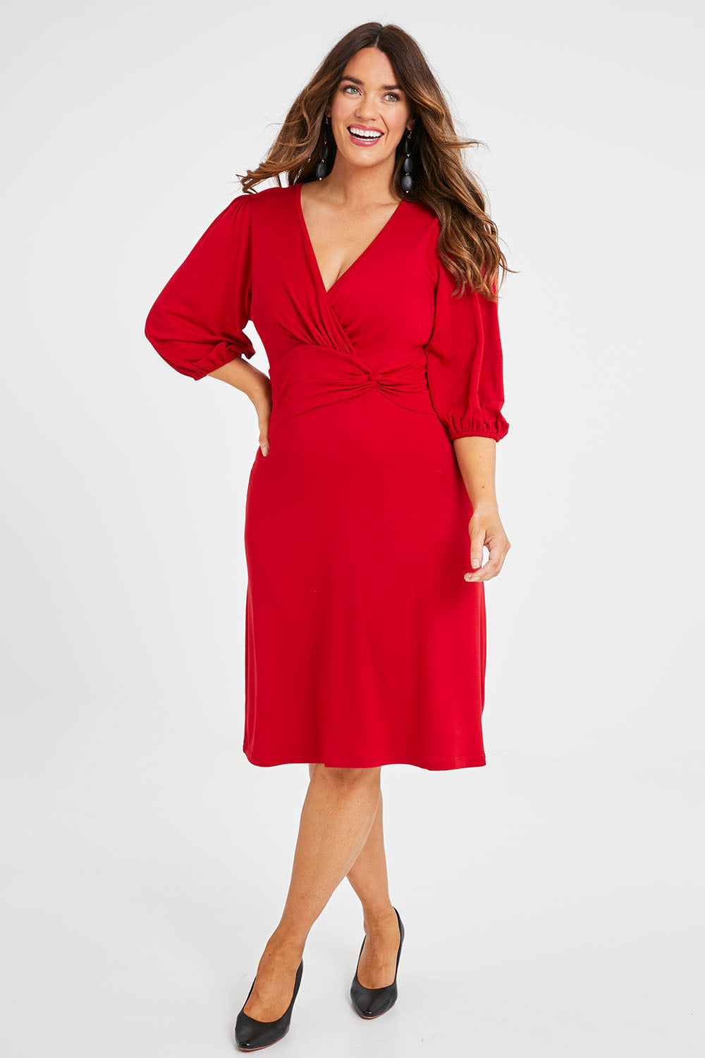 Model Laura wearing size 14 of the Gathered Waist Faux Wrap Dress in colour Flame (Red), from the front, showing the whole outfit
