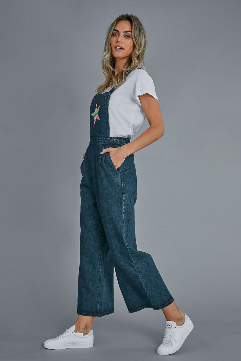 Model Alice wearing size 10 of the Star Overalls in colour Star (Blue), from the front, showing the whole outfit