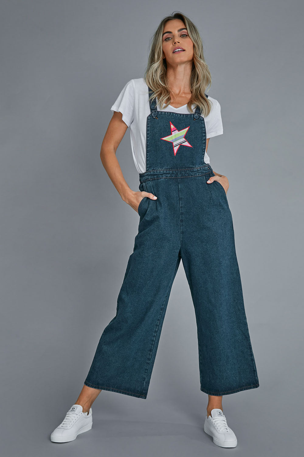 Model Alice wearing size 10 of the Star Overalls in colour Star (Blue), from the front, showing the whole outfit