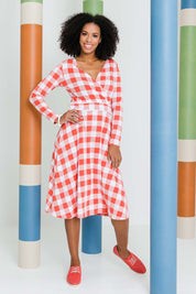 Model Schanez wearing size 10 of the Printed Faux Wrap Dress in colour Redcheck (Red), from the front, showing the whole outfit