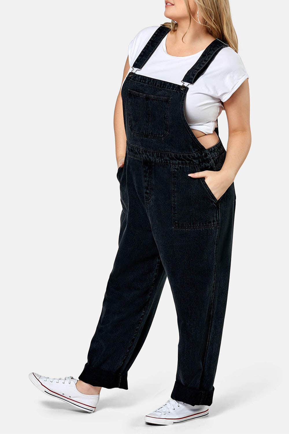 A model wearing the Matilda Overalls in colour Blackwash (Black), from the front, cropped image