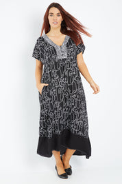 Model Laura wearing size 14 of the Evie Dress in colour Blacklinea (Black), from the front, showing the whole outfit
