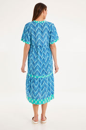 Model Madeline wearing size S of the Chevron Midi Dress in colour Ocean (Blue), from the back