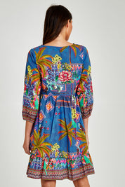Model Madeline wearing size S of the Mika Dress in colour Ocean (Blue), from the back
