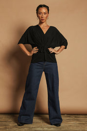Model Katie wearing size 10 of the Niamh Top in colour Black (Black), from the front, showing the whole outfit
