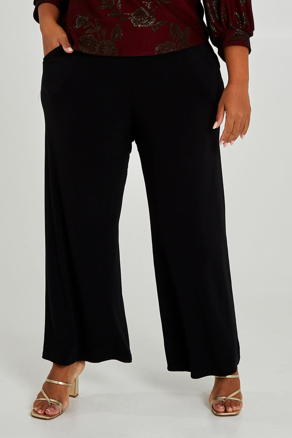 Model Alexis wearing size 18 of the Kristi Pants in colour Black (Black), from the front, cropped image