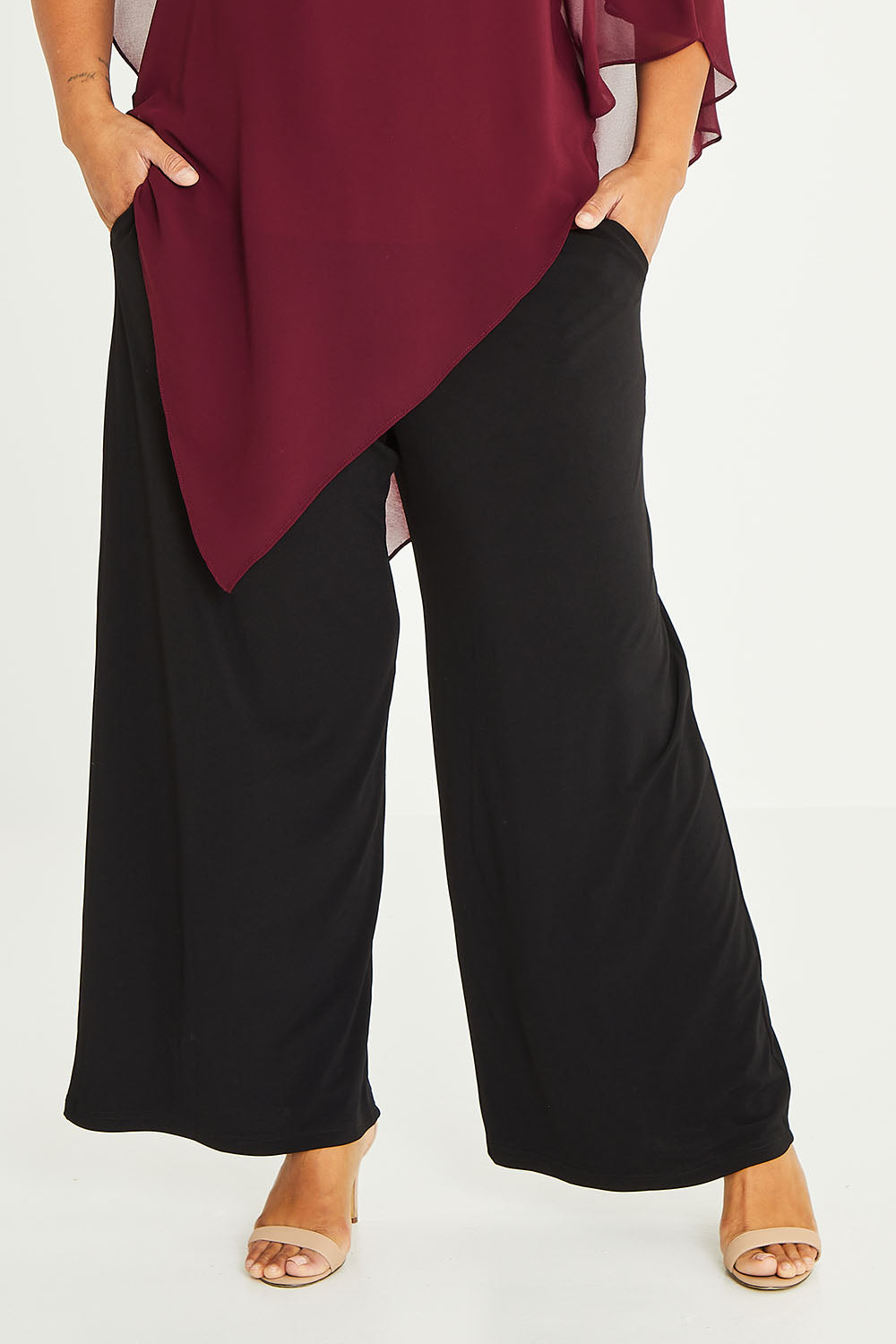 Model Palatina wearing size 16 of the Kristi Pants in colour Black (Black), from the front, cropped image