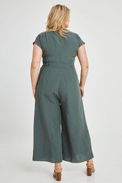 Model Keeara wearing size 16 of the Linen Blend Jumpsuit in colour Green (Green), from the back