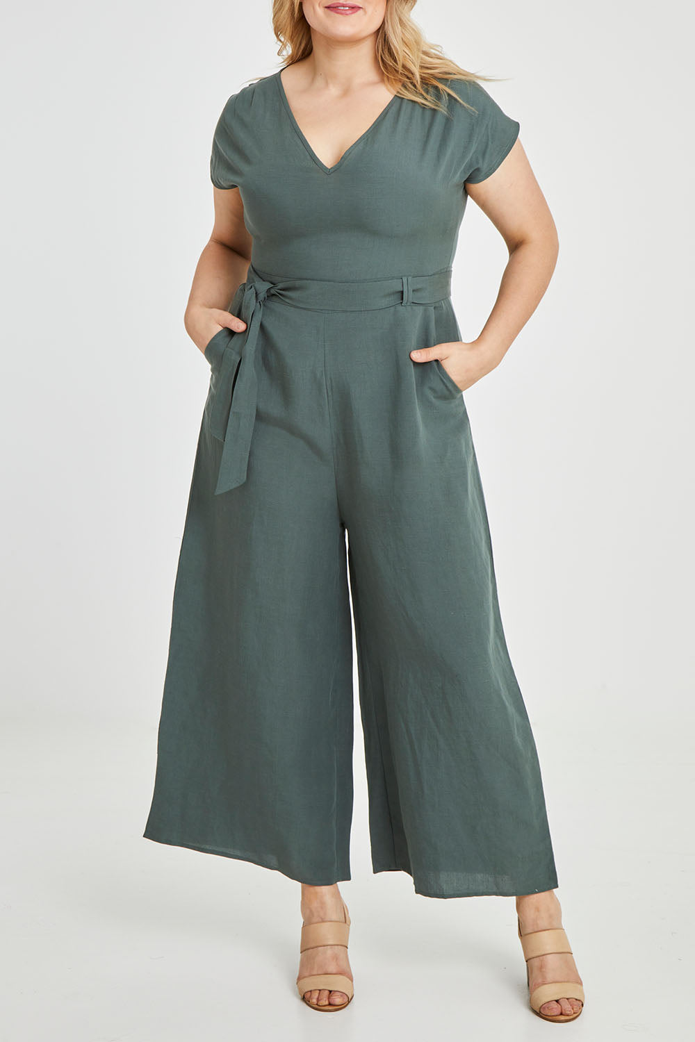 Model Keeara wearing size 16 of the Linen Blend Jumpsuit in colour Green (Green), from the front, cropped image