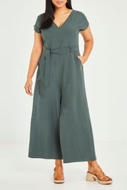 Model Terri-Leigh wearing size 14 of the Linen Blend Jumpsuit in colour Green (Green), from the front, cropped image