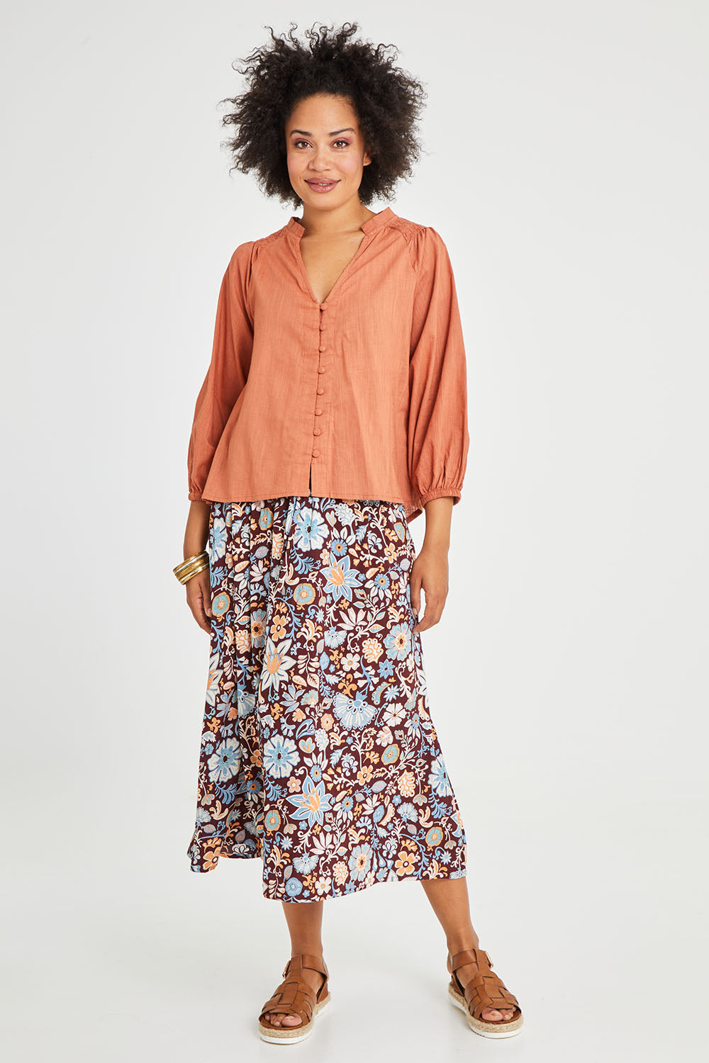 Model Olivia wearing size 10 of the Gaia Top in colour Rust, from the front, showing the whole outfit