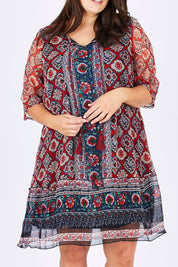 Model Mae wearing size 18 of the Urbino Print Dress in colour UrbinoPrin (Red), from the front, cropped image