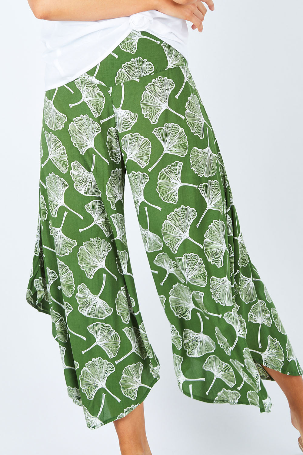 Model Madeline wearing size S of the Rayon Flare Pant in colour Greenleaf (Green), from the front, cropped image
