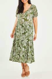 Model Terri-Leigh wearing size L of the Cotton Tiered Dress in colour Greenprint (Green), from the front, cropped image