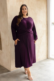 A model wearing the Eden Bamboo Dress in colour Berry (Purple), from the front, showing the whole outfit