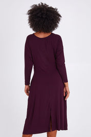 Model Olivia wearing size S of the Eden Bamboo Dress in colour Berry (Purple), from the back