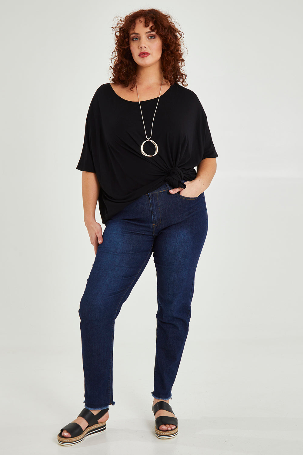 Model Maddy wearing size XXL of the Frayed Slim Fit Jean in colour Darkblue (Blue), from the front, showing the whole outfit