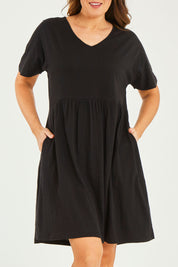 Model Georgia wearing size 10 of the Luna Ruched Dress in colour Black (Black), from the front, cropped image
