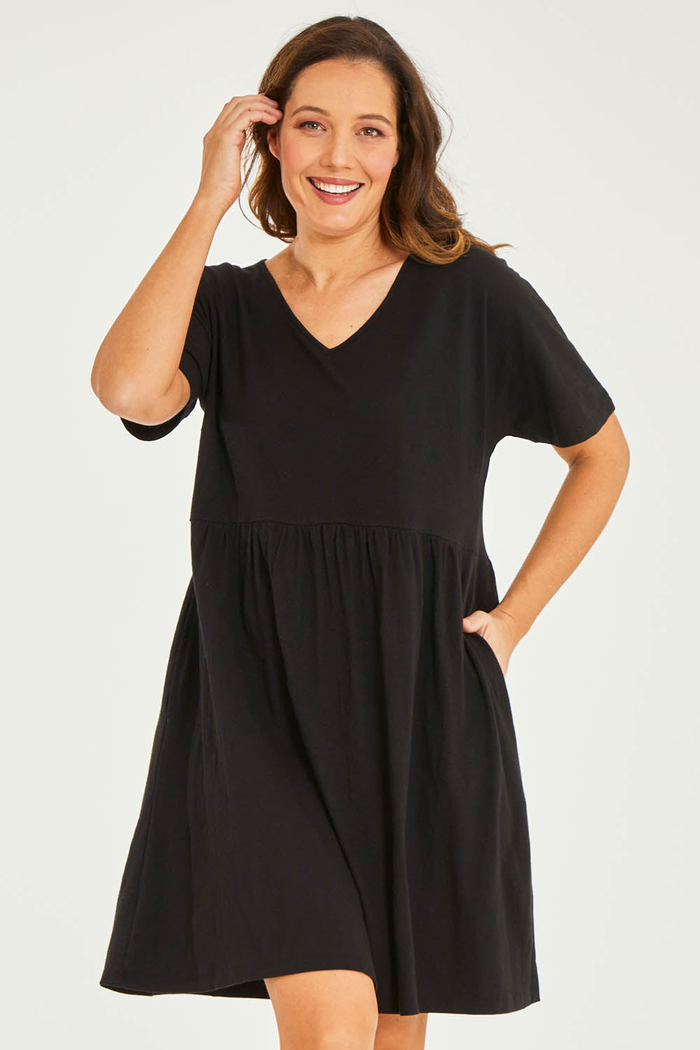 Model Georgia wearing size 10 of the Luna Ruched Dress in colour Black (Black), from the front, cropped image