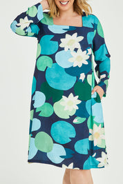 Model Jess wearing size 14 of the Foralskad Dress in colour Lilyblue (Blue), from the front, cropped image