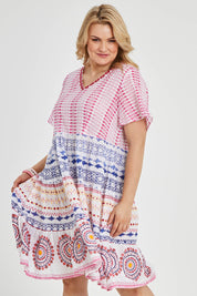 Model Keeara wearing size 16 of the Sealers Cove Cotton Dress in colour Multi (Red), from the front, cropped image