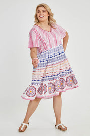 Model Keeara wearing size 16 of the Sealers Cove Cotton Dress in colour Multi (Red), from the front, showing the whole outfit