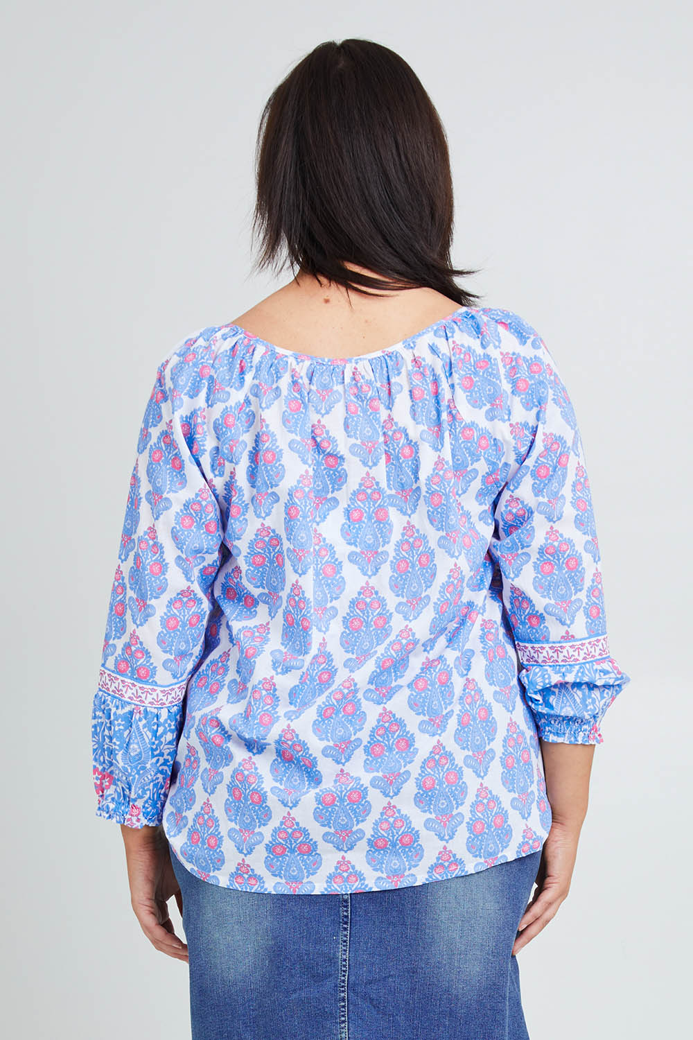 Model Poppy wearing size 16 of the Moonta Bay Cotton Blouse in colour Bluepink (Blue), from the back