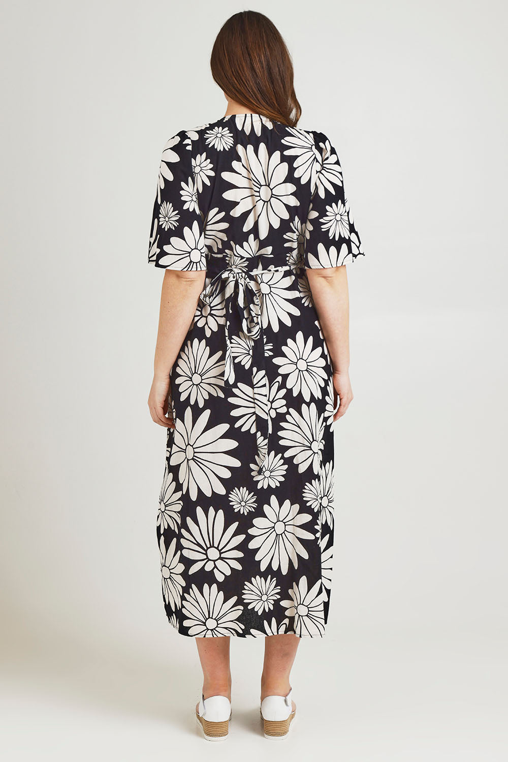 Model Jane wearing size 14 of the Gloria Cotton Wrap Dress in colour Bolddaisy (Black), from the back