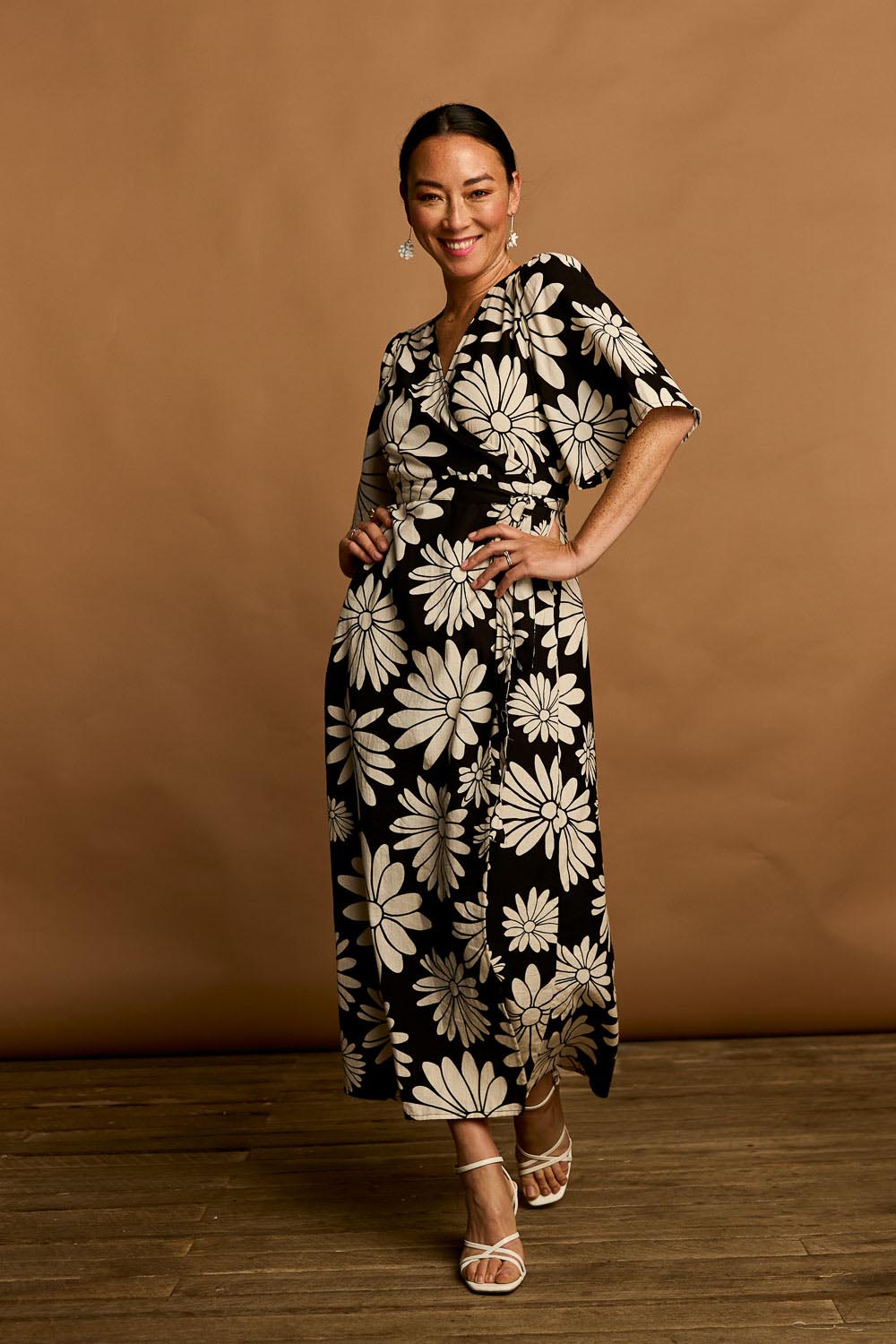 Model Katie wearing size 10 of the Gloria Cotton Wrap Dress in colour Bolddaisy (Black), from the front, showing the whole outfit