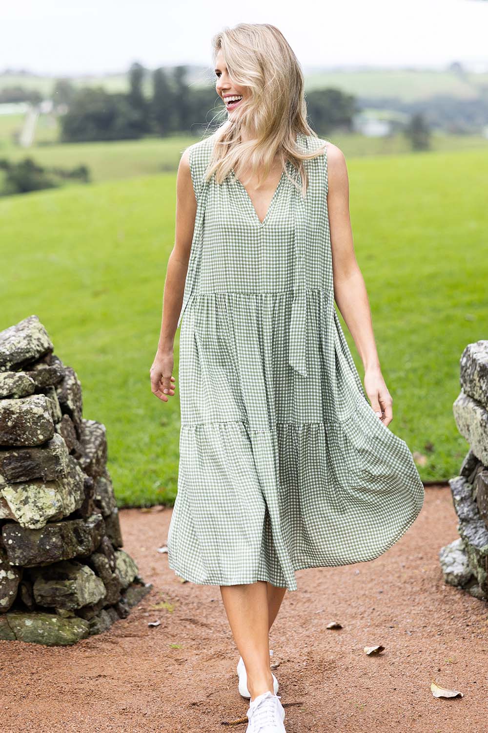 Model Kelly wearing size S of the Gingham Reversible Dress in colour Thyme (Green), from the front, showing the whole outfit