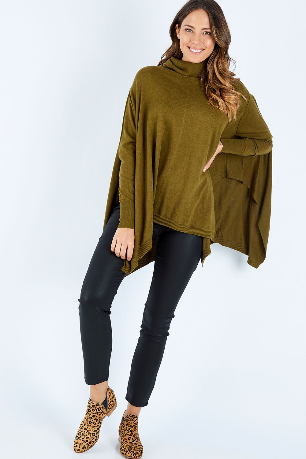 Model Madeline wearing size S of the Poncho Pullover in colour Moss (Green), from the front, showing the whole outfit