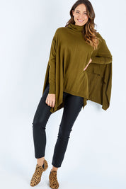 Model Madeline wearing size S of the Poncho Pullover in colour Moss (Green), from the front, showing the whole outfit
