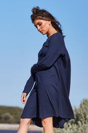 A model wearing the Pleat Back Dress in colour Ocean (Blue), from the front, showing the whole outfit