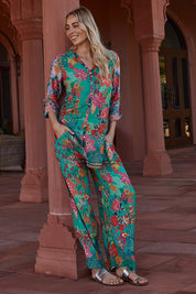 A model wearing the Eastern Pant in colour Emerald (Green), from the front, showing the whole outfit