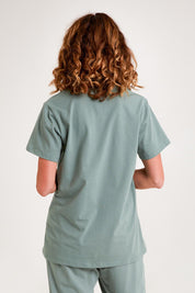 Model Emma wearing the Cotton Jersey V Neck Tee in colour Sage (Green), from the back
