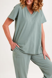 Model Emma wearing the Cotton Jersey V Neck Tee in colour Sage (Green), from the front, cropped image