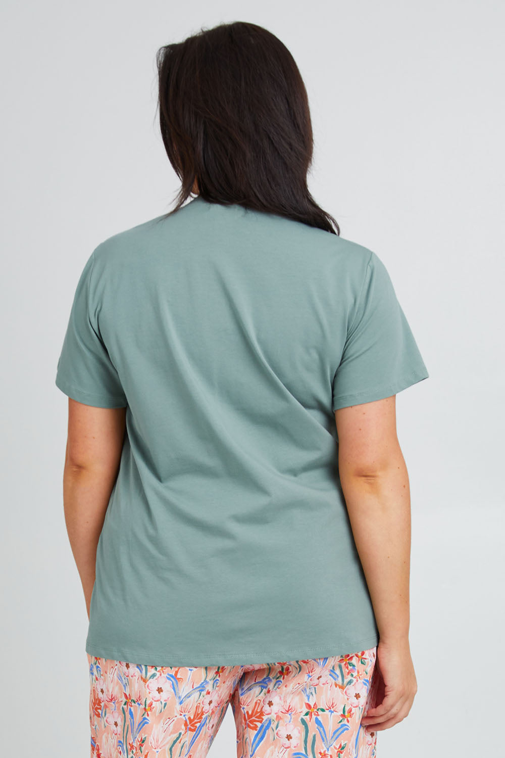 Model Poppy wearing the Cotton Jersey V Neck Tee in colour Sage (Green), from the back