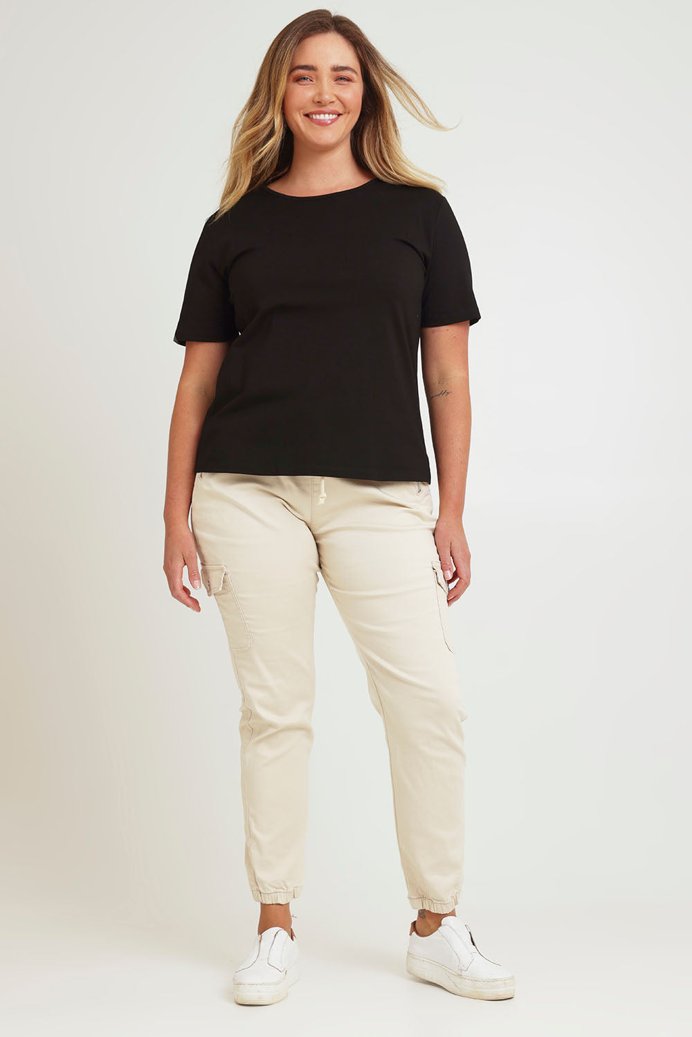 Model Chanel wearing size 16 of the Harlow Cargo Jogger in colour Beige, from the front, showing the whole outfit