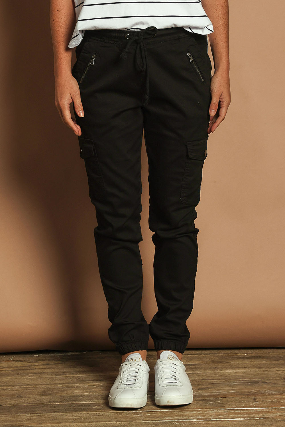 Model Katie wearing size 10 of the Harlow Cargo Jogger in colour Black (Black), from the front, cropped image