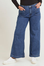 Model Chanel wearing size 16 of the Katie Highin colourWaisted Front Pocket Wide Leg Jean - Middenim (Blue), from the front, cropped image