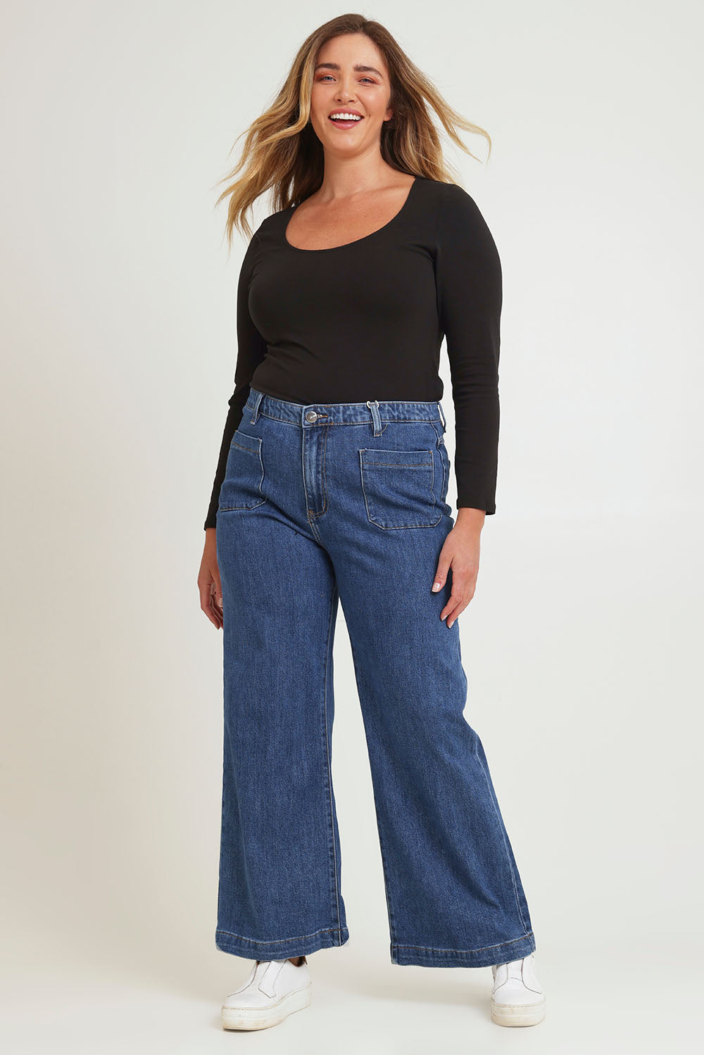 Model Chanel wearing size 16 of the Katie Highin colourWaisted Front Pocket Wide Leg Jean - Middenim (Blue), from the front, showing the whole outfit