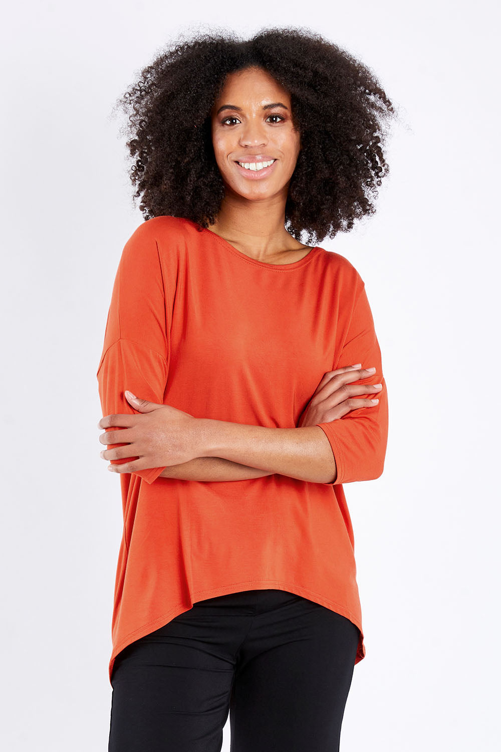 Model Schanez wearing size S of the Relaxed High Low Bamboo Top in colour Tangerine, from the front, cropped image